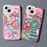 two cases with illustrations of a city and a pink background