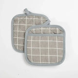 two grey and white pot holders with a grid pattern