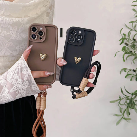 Two heart-adorned phone cases with wrist straps.