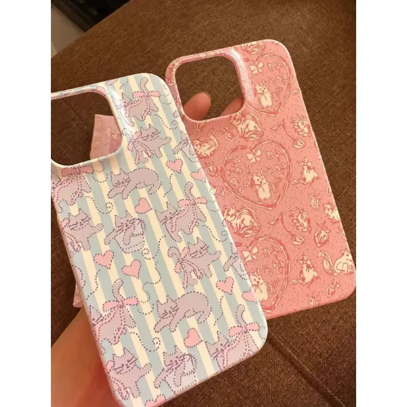 two iphone cases with unicorns and hearts on them