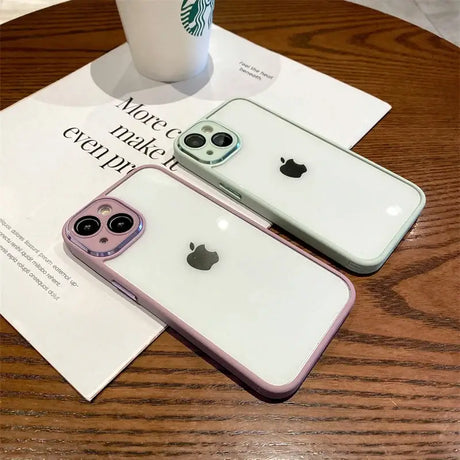 There are two iphones sitting on a table next to a cup of coffee