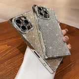 Two glittering, jewel-encrusted smartphone cases with camera cutouts.