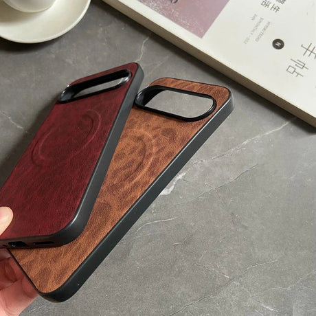 Two leather-textured phone cases, one maroon and one brown, with black frames and raised camera cutouts.