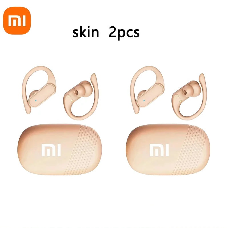 Two pairs of beige wireless earbuds with ear hooks and their matching charging cases.