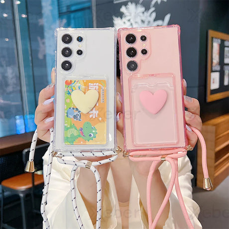 Two phones in clear, heart-decorated cases with shoulder straps.
