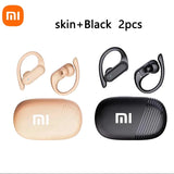 Two sets of Xiaomi wireless earbuds with ear hooks, one in a skin/beige color and one in black, each with its matching charging case.