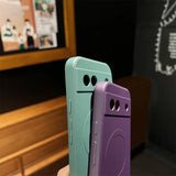 Two smartphone cases with cartoon-like eyes, one mint green and one purple.