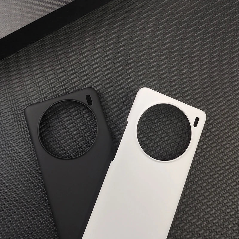 Two smartphone cases with circular cutouts, one black and one white.