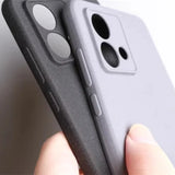 Two smartphone cases, one dark gray and one light gray, featuring raised button covers and distinct camera cutouts.