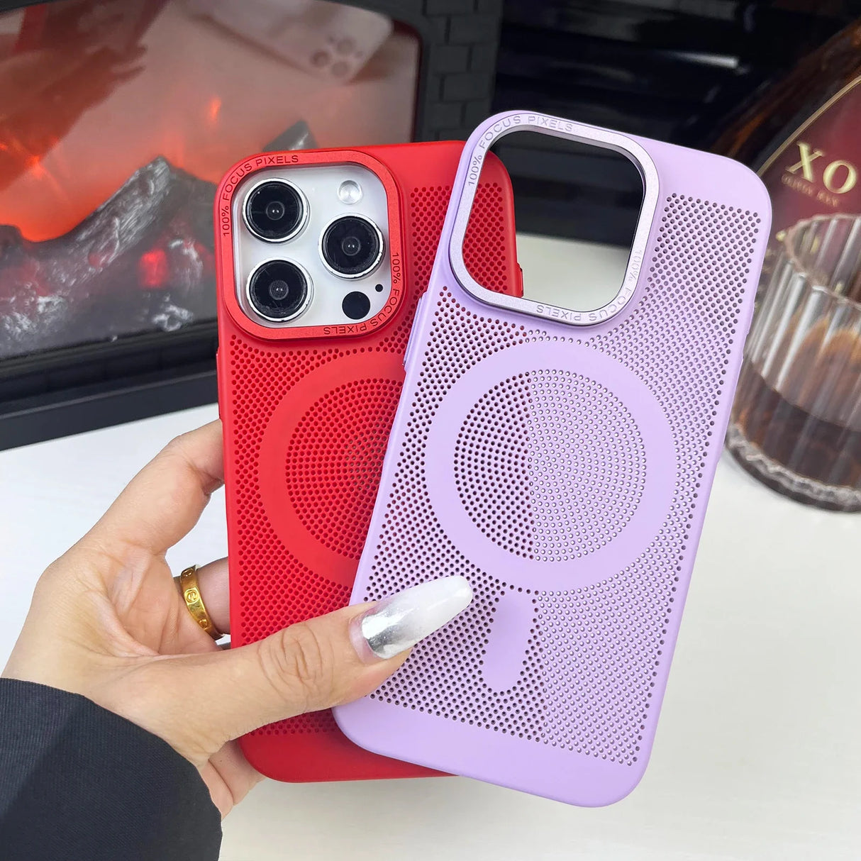 Two smartphone cases, one red and one purple, with circular perforated patterns.