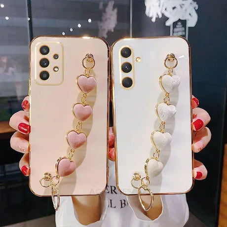 Two smartphones with decorative heart-shaped charms attached.