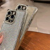 Two sparkly silver iPhone cases with diamond-encrusted camera cutouts and side bezels.