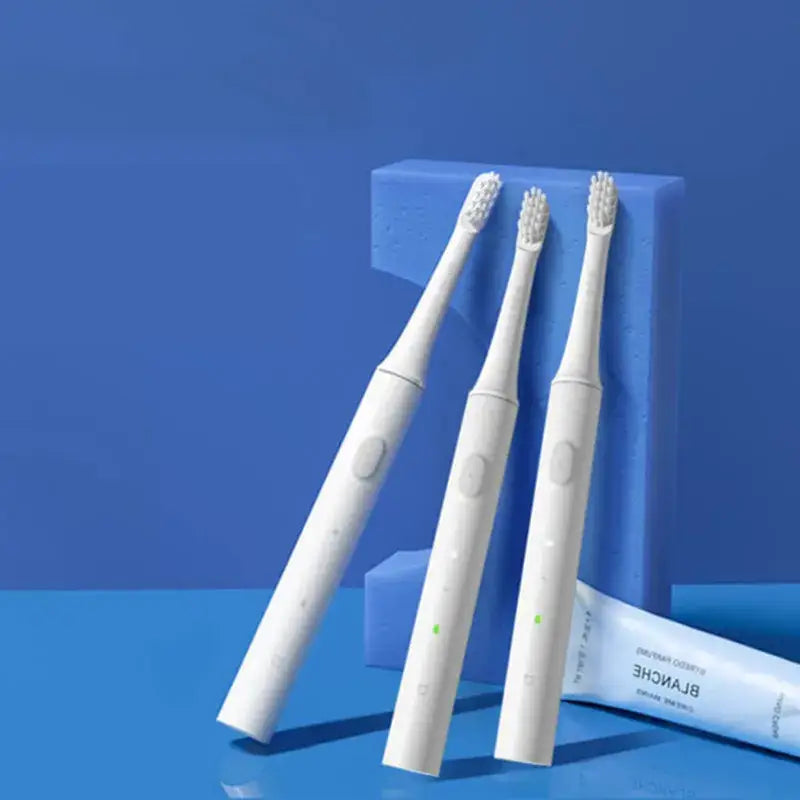 two toothbrushs sitting on a blue surface