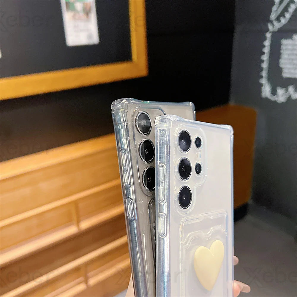 Two transparent smartphone cases, one with a yellow heart design.