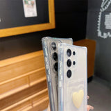 Two transparent smartphone cases, one with a yellow heart design.