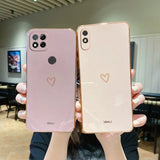 two women holding up their iphones with hearts on them
