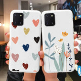 two women holding up their phone cases with hearts and flowers