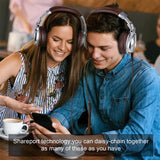 Two young people wearing headphones and looking at a smartphone together.
