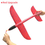 a hand holding a red airplane with blue spe