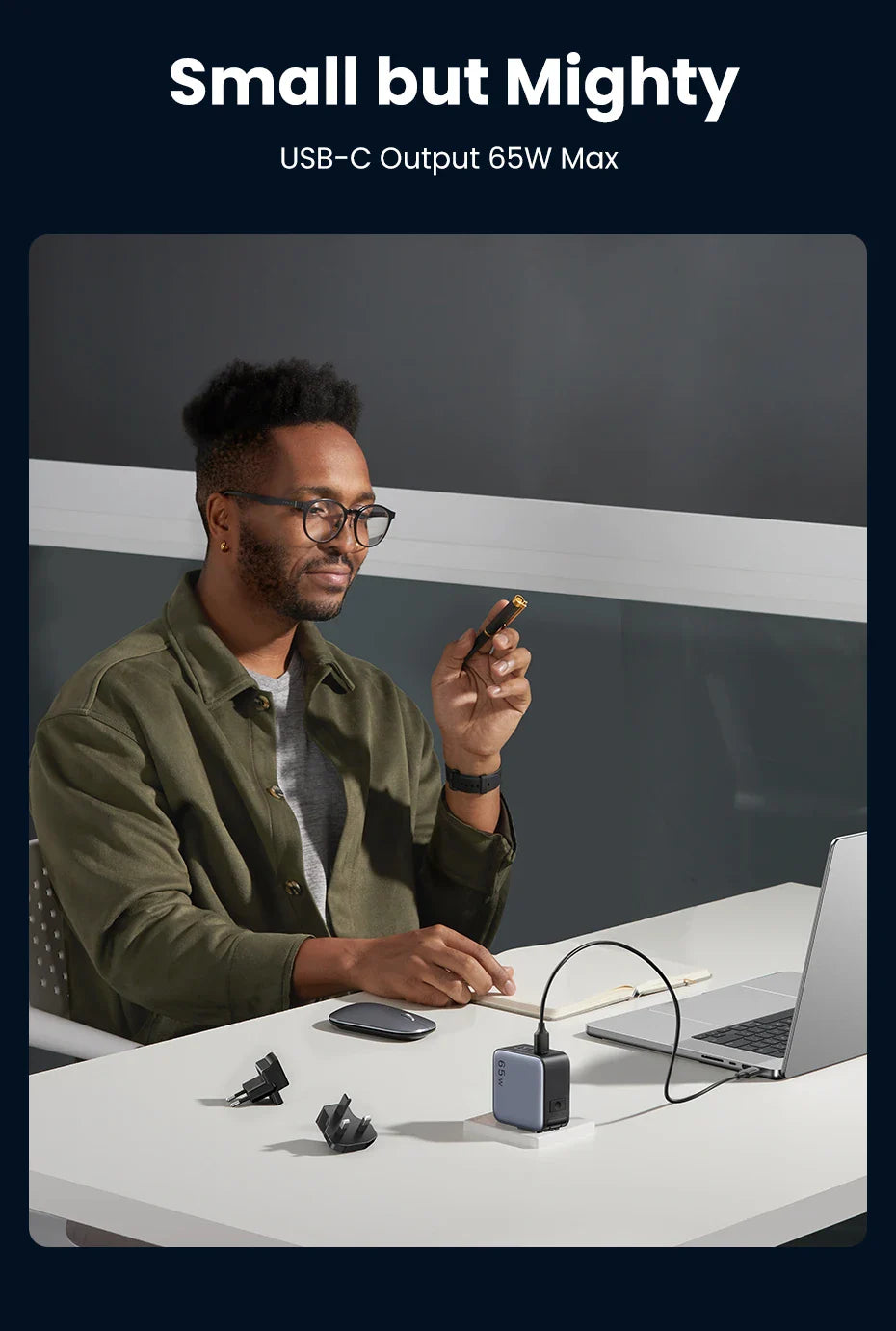 USB-C charger or power adapter shown on a desk with a person using a laptop.