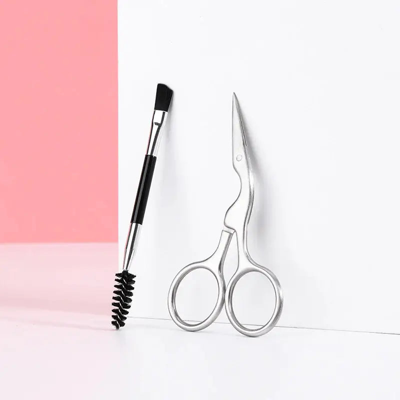 a pair of scissors and a brush on a pink background