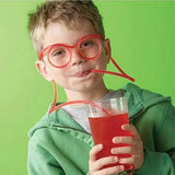 a young boy wearing glasses and drinking a drink
