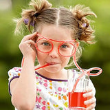 a little girl with glasses holding a glass of juice