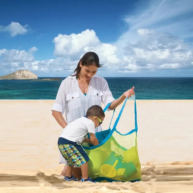 a woman and child playing in the sand on a beach