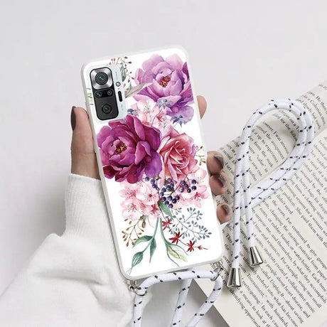 a woman holding a phone case with flowers on it