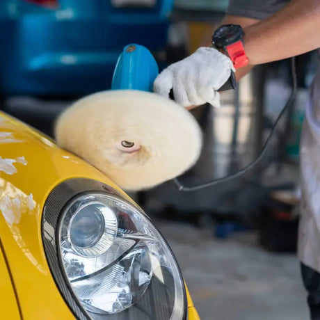 a man waxing a yellow car