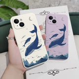 a woman holding a phone case with a whale on it