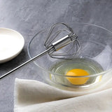 there is a whisk in a bowl with an egg inside of it