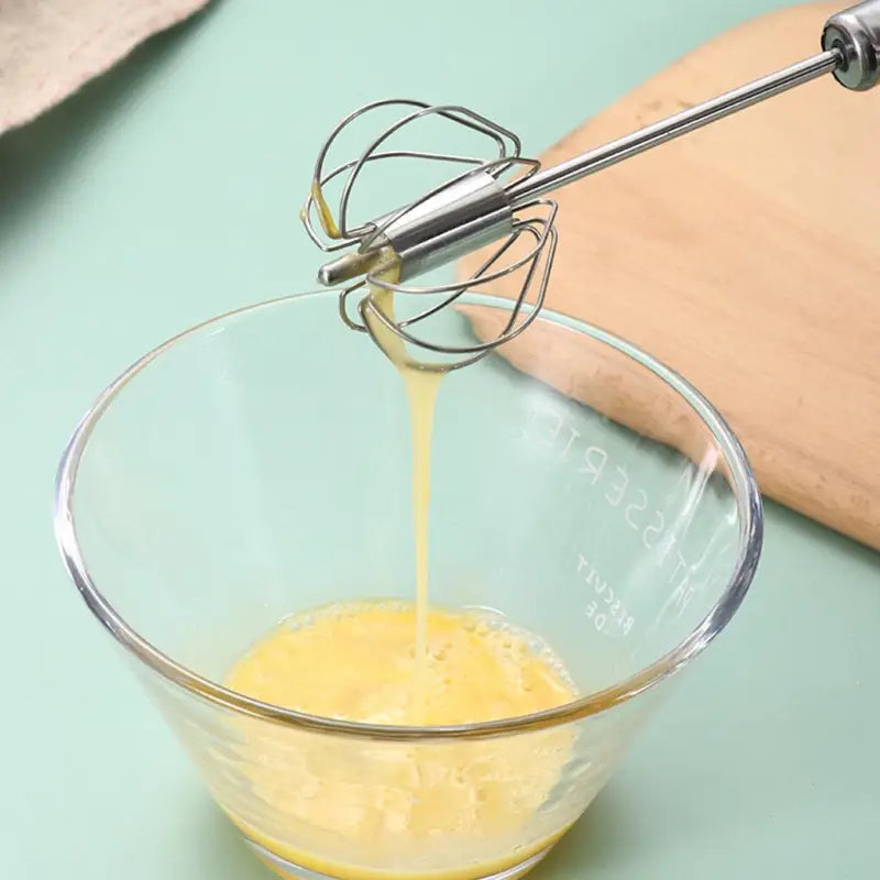 a bowl filled with liquid next to a whised egg