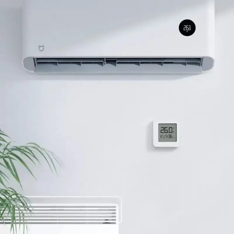 A white air conditioner sitting on top of a white wall