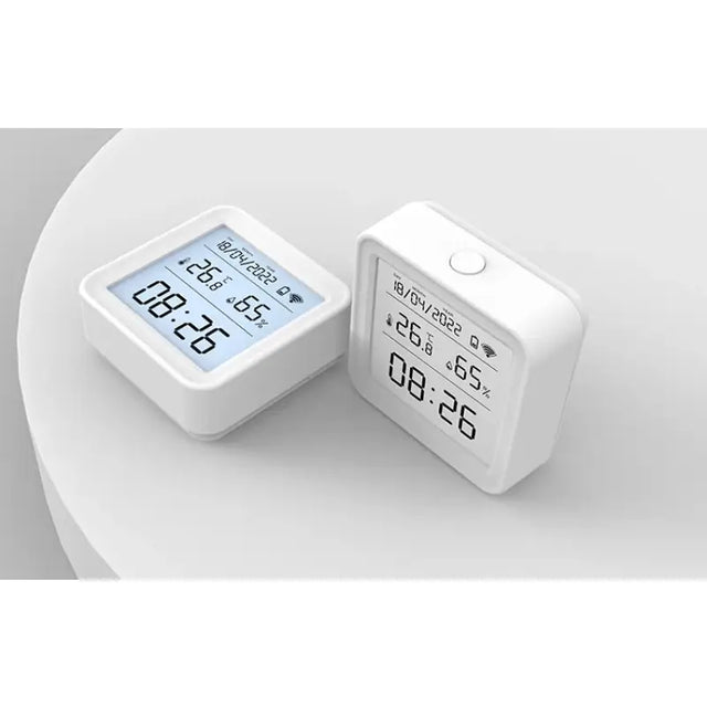 a white alarm clock sitting next to a white square clock