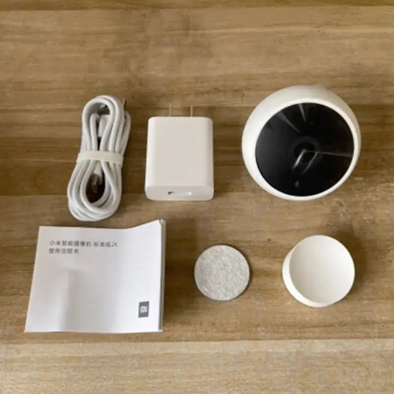 a white and black alarm clock sitting on top of a wooden table