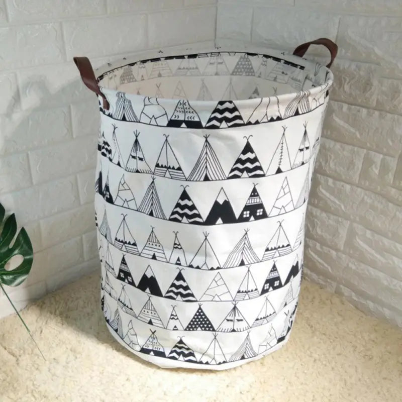 a white and black patterned fabric basket with a wooden handle