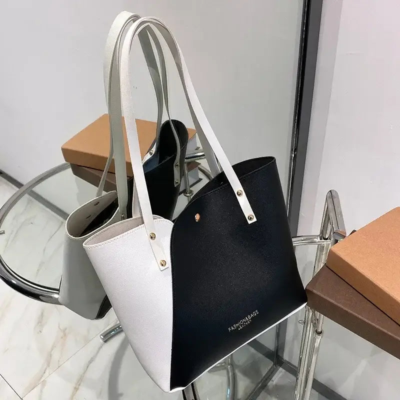 a white and black handbag with a black handle
