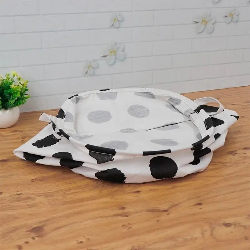 a white and black polka dot print pot cover on a wooden table
