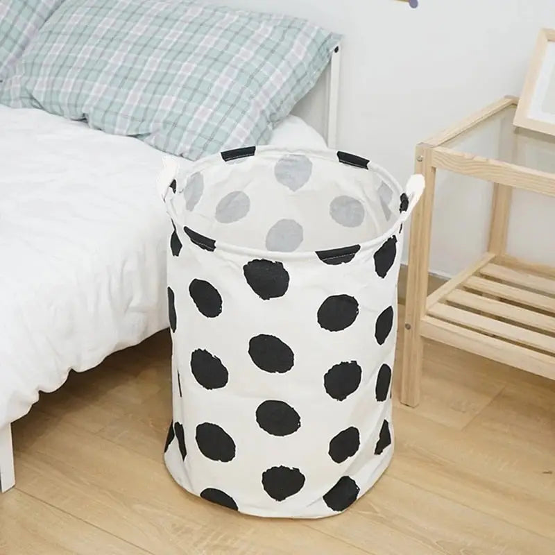 there is a black and white polka dot print laundry basket on the floor