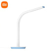 a white and blue lamp with a blue base on a white surface