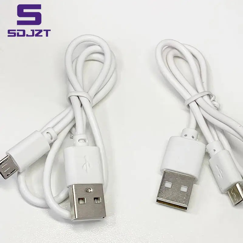 two white usb cables connected to a white laptop computer