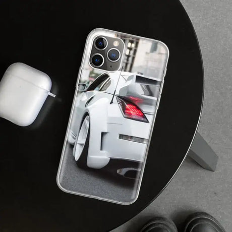 A white car with a red tail on a black table