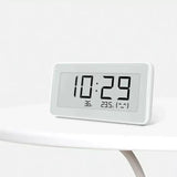 a white clock sitting on top of a table