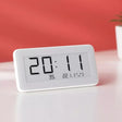 A white clock sitting on top of a table