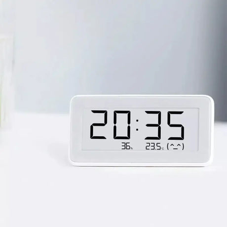 A white clock sitting on top of a table