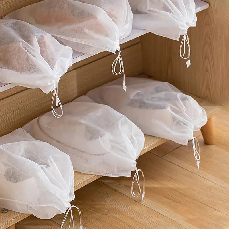 a set of three white bags with draws on them