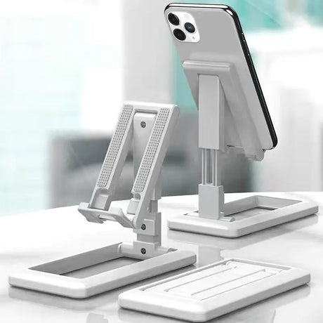 a white desk with two white stands and a phone