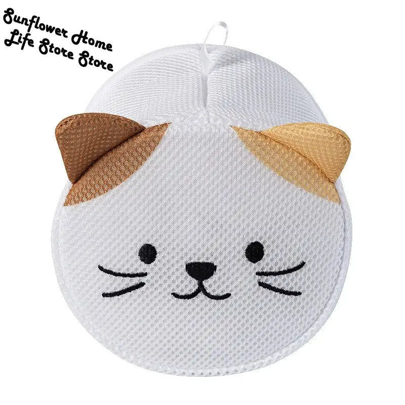 a white cat face shaped pillow with a brown nose