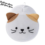 a white cat face shaped pillow with a brown nose
